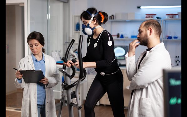 athlete-woman-with-mask-running-gym-bycle-trainning-body-endurance-while-researcher-doctor-measuring-heart-rate-monitoring-egk-data-laboratory-sportwoman-with-medical-electrodes-it
